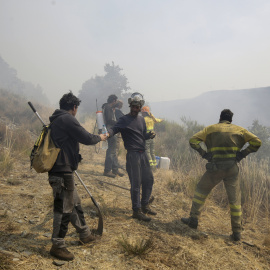Bomberos forestales extinguen el fuego en el incendio que se desató el pasado 19 de agosto en Palacios de Compludo (León).