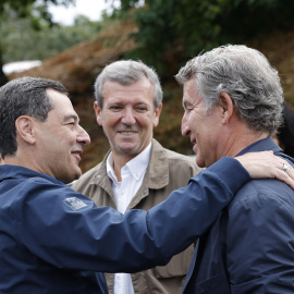 El líder del PP, Alberto Núñez Feijóo (d), saluda al presidente de la Junta de Andalucía, Juanma Moreno (i), en presencia del presidente de la Xunta de Galicia, Alfonso Rueda (c), a su llegada al acto de inauguración de la temporada política este domingo en la localidad pontevedresa de Cerdedo-Cotobade. EFE/ Lavandeira Jr