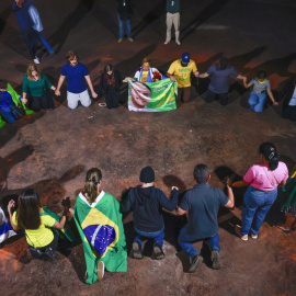 Simpatizantes del expresidente de Brasil Jair Bolsonaro forman un circulo de oración cerca a su residencia este lunes, en Brasilia (Brasil).