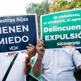 Dos hombres con carteles durante la protesta organizada por Vox contra el centro de Primera Acogida de Hortaleza, este 2 de septiembre de 2025 en Madrid.