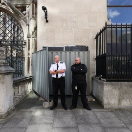 Guardias de seguridad tapan la nueva obra de Banksy en Londres.