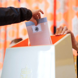 Un votante introduce la papeleta en la urna en un colegio electoral de Oslo.