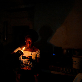 Una mujer prepara una vela durante el apagón nacional en Cuba.