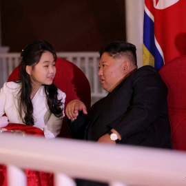 El líder norcoreano Kim Jong-un y su hija Kim Ju Ae conversan mientras asisten a la ceremonia de botadura de un buque de guerra.