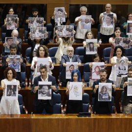 Diputados regionales de Más Madrid muestran fotos de palestinos asesinados en Gaza.