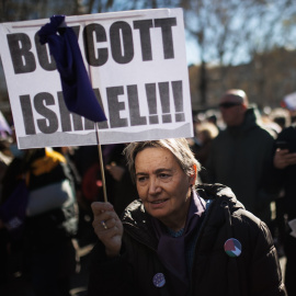 Una mujer con un cartel en el que se lee: 'Boicot Israel' durante una manifestación en apoyo a Palestina.