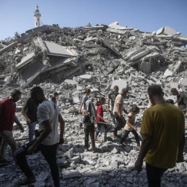 Palestinos inspeccionan los escombros del edificio residencial Al-Ghafari tras ser alcanzado por un ataque aéreo israelí en la ciudad de Gaza.