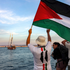 Imagen de archivo de un hombre ondeando una bandera frente a una de las embarcaciones que integra La Flotilla.