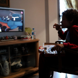 Un niño come un trozo de pizza en una foto de archivo.