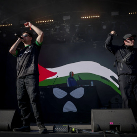 El grupo irlandés Kneecap actúa con una bandera de apoyo a Palestina.