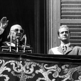 El dictador Francisco Franco acompañado por el entonces Príncipe de España, Juan Carlos de Borbón, desde el balcón principal del Palacio de Oriente el 1 de octubre de 1975