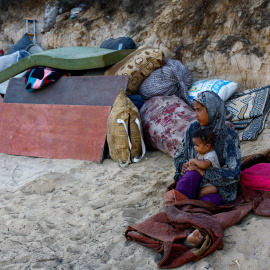 Una mujer palestina desplazada con un niño, que huye del norte de Gaza debido a una operación militar israelí, descansa después de evacuar hacia el sur siguiendo las órdenes de las fuerzas israelíes de abandonar la ciudad de Gaza, en el centro de la Franja de Gaza, el 23 de septiembre de 2025. REUTERS/Mahmoud Issa