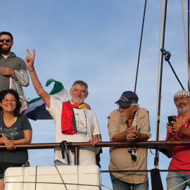 Varios activistas de la Flotilla se asoman a bordo de una de las embarcaciones que la integran.