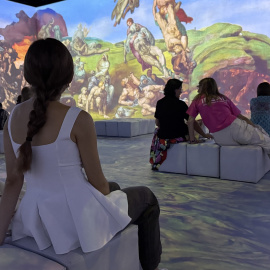 Diverses persones observant les projeccions d'una de les sales de l'experiència immersiva 'Leonardo versus Michelangelo' a l'IDEAL de Barcelona
