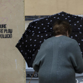 Una mujer se protege de la lluvia con un paraguas en València.