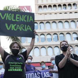 Un mujer con un cartel en el que se lee "Violencia vicaria".