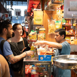 Varias personas compran en el mercado de la Boquería, en Barcelona.