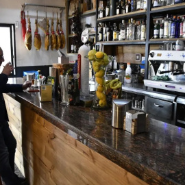 Un cliente toma una consumición en el bar de un pueblo.