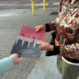 Un dels voluntaris repartint un diari que crida a manifestar-se aquest dissabte