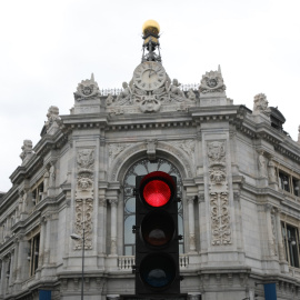 Un semáforo en rojo cerca del edificio del Banco de España, en Madrid.