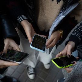 Varias personas usando el teléfono móvil.