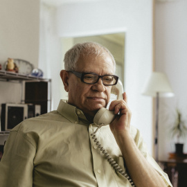 Una persona mayor hablando por teléfono.