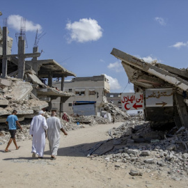Residentes caminan entre edificios de hormigón derrumbados en Jan Yunis, Gaza, el 5 de octubre de 2025