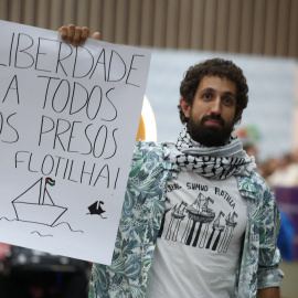 El activista Nico Calabrese, detenido por Israel mientras participaba en la Flotilla Global Sumud que buscaba entregar ayuda a Gaza, muestra un cartel que dice "Libertad a todos los prisioneros de la Flotilla" a su llegada al Aeropuerto Internacional Galeao en Río de Janeiro, Brasil, el 6 de octubre de 2025. REUTERS/Pilar Olivares