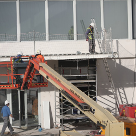 Foto de archivo de obreros junto a grúas continúan trabajando.