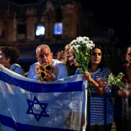 Israelíes con flores y banderas a la llegada de vehículos con los cuerpos de cuatro rehenes entregados por Hamás.