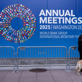 Un guardia de seguridad junto al cartel que anuncia la Asamblea Anual del FMI, en la sede de la institución internacional, en Washington DC.