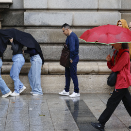 Personas se protegen de la lluvia en Madrid.