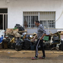 Un hombre pasea por una calle llena de barro, a 13 de octubre de 2025, en La Ràpita, Tarragona, Catalunya (España).