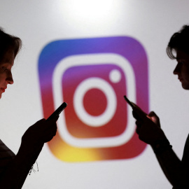 Personas miran su teléfono (foto de archivo).