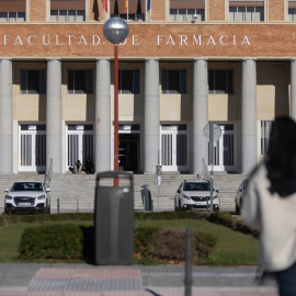 Una persona camina junto a la Facultad de Farmacia, en la Universidad Complutense de Madrid.