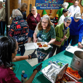 Personas reciben comida en un banco de alimentos.