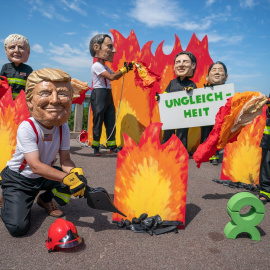 Trump junto a dirigentes históricos en una protesta climática de Oxfam contra el G7 (Archivo).