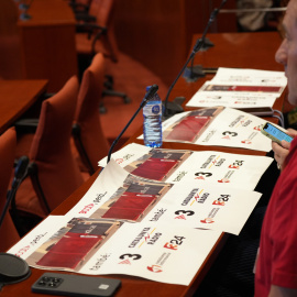 Representants dels treballadors de la CCMA seguint una sessió de control al Parlament amb uns cartells que reivindiquen les marques històriques de la corporació