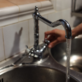 Una persona obre una aixeta de la cuina