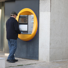 Un hombre saca dinero en un cajero automático Madrid