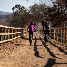 Dues persones anant amb bicicleta per una via verda de Girona