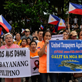 Manifestantes sujetan pancartas llamando a la resignación del presidente Ferdinand Marcos Jr.