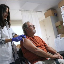 Imatge d'arxiu d'una professional del CAP Les Corts que vacuna un home de la COVID-19 i la grip.