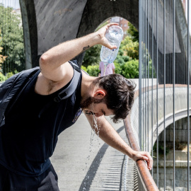 Un hombre se refresca con agua durante una ola de calor, en agosto de 2025.