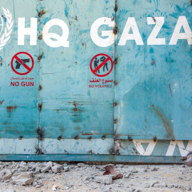 Imagen de archivo de un niño está sentado frente a la entrada de un complejo de edificios de Naciones Unidas en Gaza.