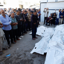 Personas asisten al funeral de los palestinos que  murieron en los ataques israelíes de este sábado, en el Hospital de los Mártires de Al-Aqsa, en el centro de la Franja de Gaza.
