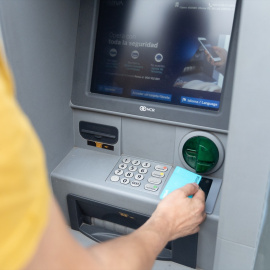 Un hombre saca dinero de un cajero automático.