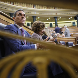 El presidente del Gobierno, Pedro Sánchez y la vicepresidenta primera y ministra de Hacienda, María Jesús Montero, en sus escaños en el Congreso este miércoles.