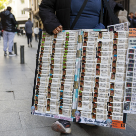 Un vendedor de loterías junto a la administración de lotería Doña Manolita.
