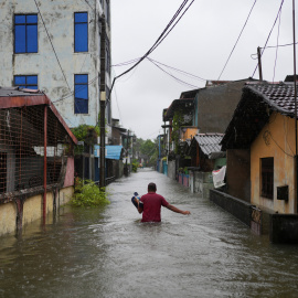 Un hombre camina por una calle inundada en Sri Lanka.